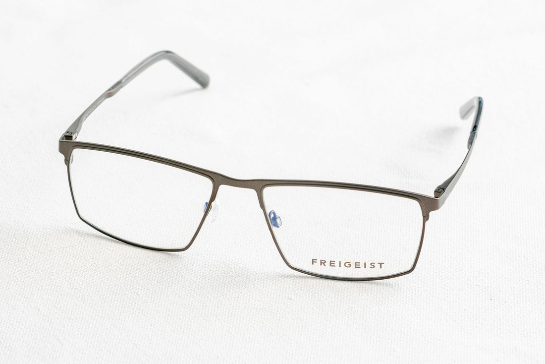 Close-up of stylish Freigeist eyeglasses on white surface, minimalist style.