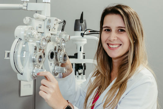 Female optician in white coat smiling while using phoropter. Perfect for healthcare imagery.