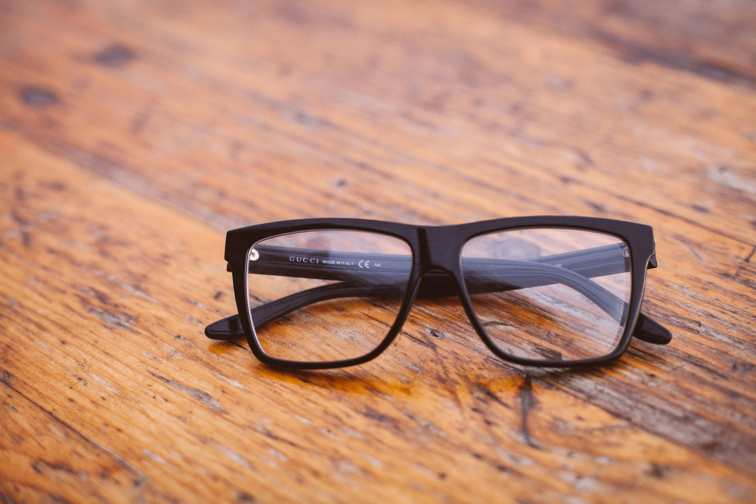 Close-up of fashionable eyeglasses resting on a wooden table indoors.