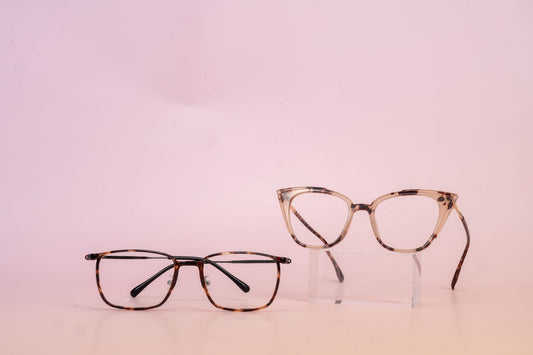 Two stylish glasses on a pink background for modern eyewear fashion.
