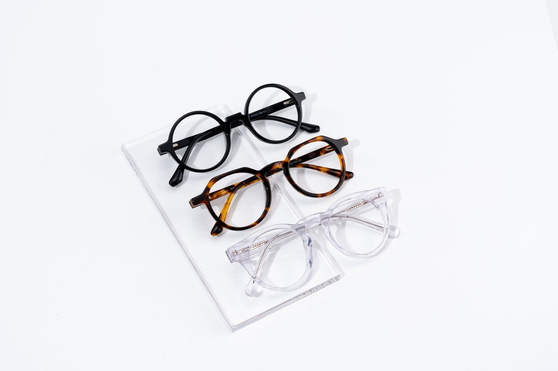Three pairs of eyeglasses displayed on a white surface showcasing classic and stylish fashion eyewear.