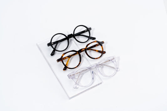 Three pairs of eyeglasses displayed on a white surface showcasing classic and stylish fashion eyewear.