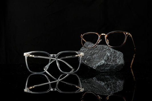 Stylish eyeglasses showcased on a reflective black surface, emphasizing modern fashion and optical design.