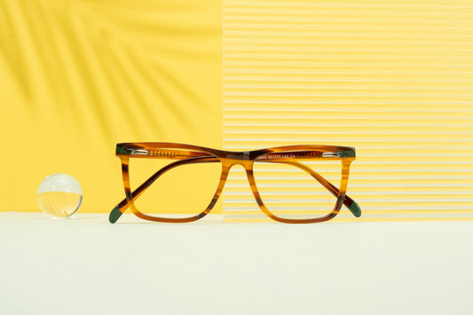Elegant eyeglasses displayed on a vibrant yellow background with modern aesthetic appeal.