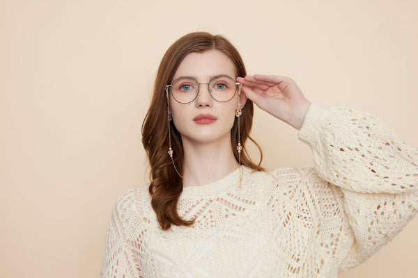 Portrait of a woman in glasses with beige background, embracing fashion style.