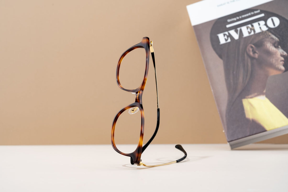Elegant tortoiseshell eyeglasses displayed next to a fashion magazine, evoking a modern style.
