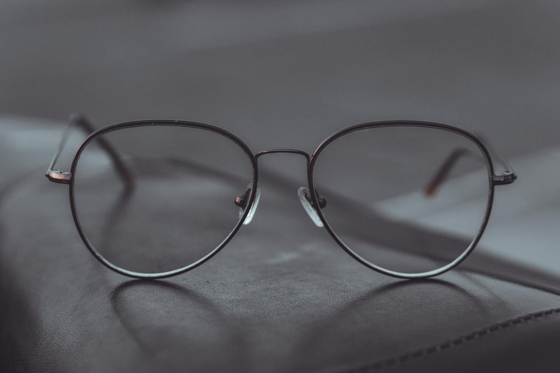Stylish aviator glasses resting on a leather surface, showcasing sleek design.
