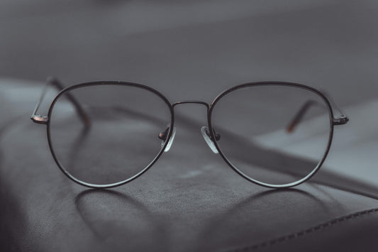 Stylish aviator glasses resting on a leather surface, showcasing sleek design.
