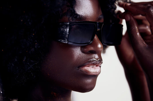Close-up portrait of a stylish black woman wearing modern sunglasses, showcasing elegance and confidence.