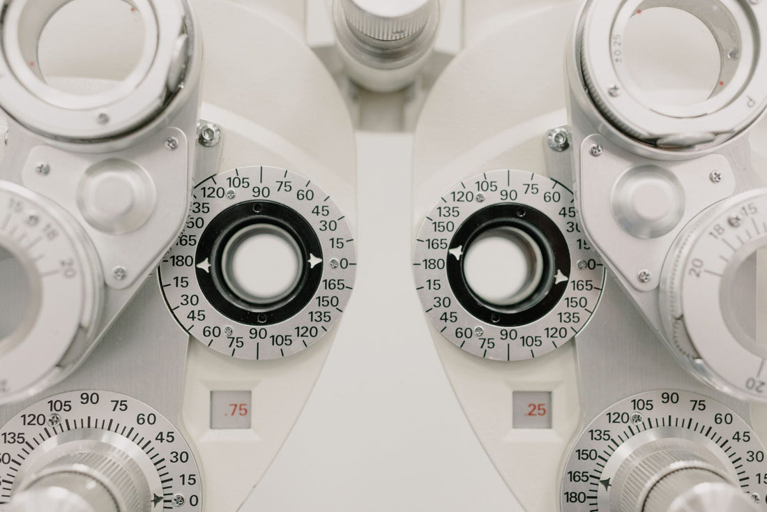 Modern white ophthalmic phoropter with optometric glasses for measuring eyesight made of metal placed on white background in contemporary clinic