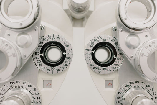 Modern white ophthalmic phoropter with optometric glasses for measuring eyesight made of metal placed on white background in contemporary clinic