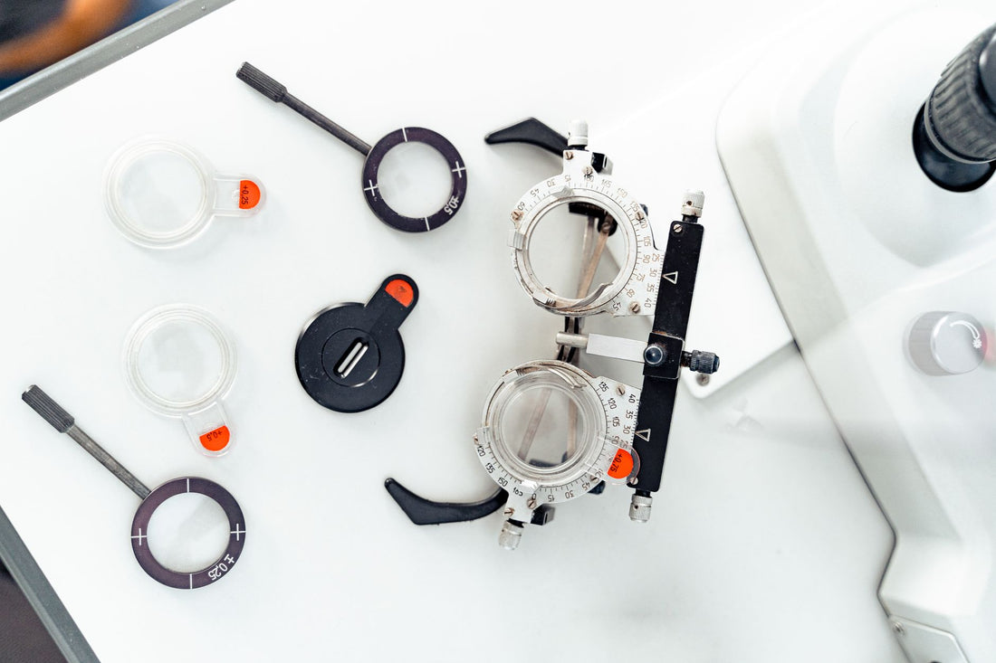 High-angle shot of optometry trial frames and lenses on a white surface.
