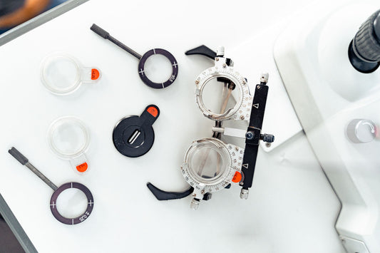 High-angle shot of optometry trial frames and lenses on a white surface.