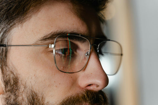 Detailed close-up of a man's side profile with eyeglasses and beard.
